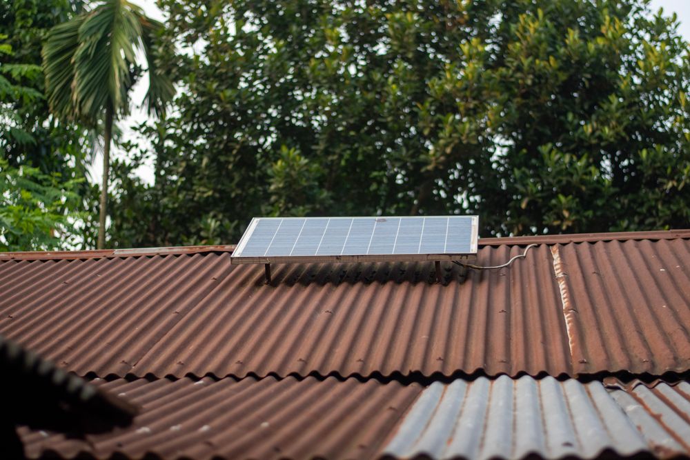 A small solar panel mounted on a corrugated iron roof